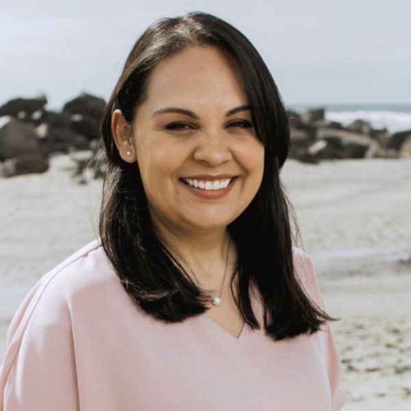 Angelica Quezada, LCSW, PMH-C, smiling on a beach