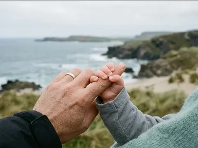 A tiny hand wrapped around an adult finger, warm and intimate close-up, representing the themes of "Baby Blues: Symptoms, Timeline, and When to Expect Relief".