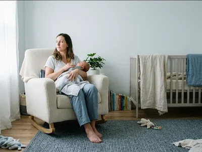 A figure near a window in a quiet domestic interior, unhurried and still, representing the themes of "Does Birth Trauma Get Better? What Healing Actually Looks Like".