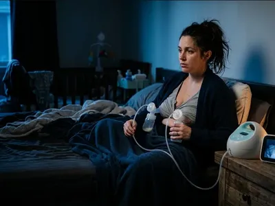 A mother exclusively pumping alone at 3am in soft nighttime light, illustrating the emotional isolation of the exclusive pumping schedule