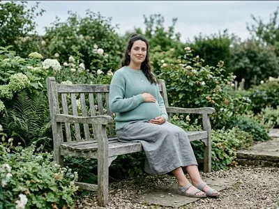 A pregnant person on a garden bench, gentle morning light, looking forward, representing the themes of "Pregnant Again After PPD: A Proactive Plan to Protect Your Mental Health".