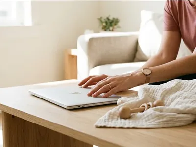 A parent on a couch, infant nestled on their chest, both still and quiet, representing the themes of "Going Back to Work After Baby: What Is Actually Happening and What Helps".